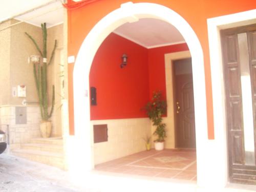 サンニコーラにあるCasa Vacanze Libertàの赤壁の家のアーチ入口