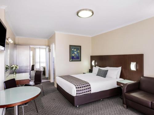 a hotel room with a bed and a table at BreakFree Queanbeyan in Queanbeyan