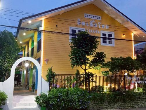 a yellow house with a fence in front of it at ลิตเติ้ลโฮม ที่พักเพชรบุรี in Phetchaburi