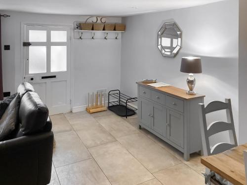 a living room with a couch and a table at Cosy Cottage in Portinscale