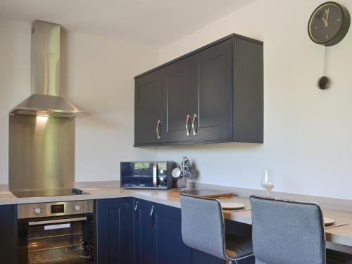 a kitchen with blue cabinets and a table with chairs at Kestrel View in Skipton