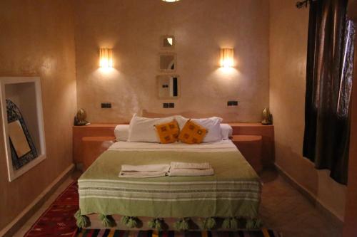 a bedroom with a bed with two pillows on it at Maison Hassan Merzouga in Merzouga