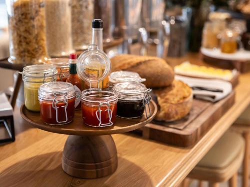 a tray with jars of honey and a bottle on a table at Novotel Sydney City Centre in Sydney