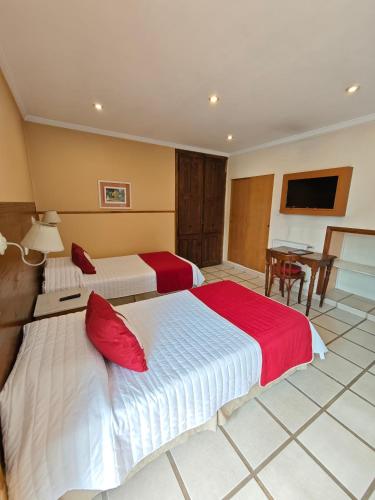 a hotel room with two beds and a table at Hotel Francia in Tandil