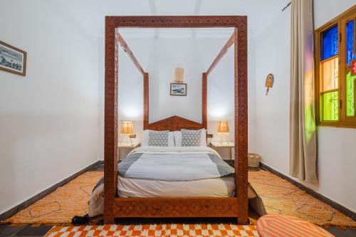 a bedroom with a canopy bed with a mirror at Dar Salah - Eddine Oasis Pool & SPA in Oulad Mazoug