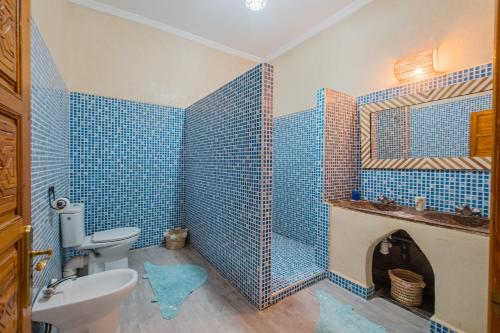 a blue tiled bathroom with a toilet and a sink at Dar Salah - Eddine Oasis Pool & SPA in Oulad Mazoug