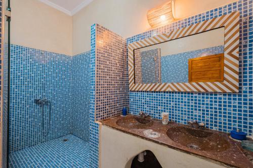 a blue tiled bathroom with a sink and a mirror at Dar Salah - Eddine Oasis Pool & SPA in Oulad Mazoug
