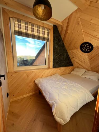 a bed in a room with a window at Apartamenty pod Tatrami in Zakopane