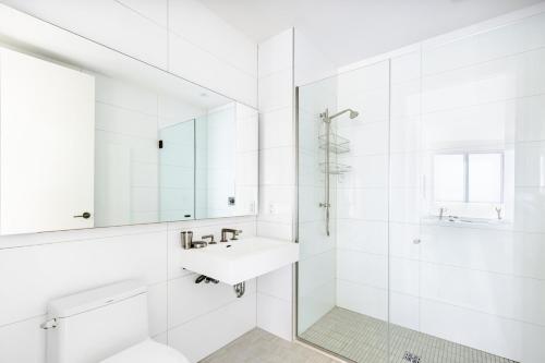 a white bathroom with a sink and a mirror at Blueground Clinton Hill rooftop pool nr Prospect Park NYC-1961 in Brooklyn
