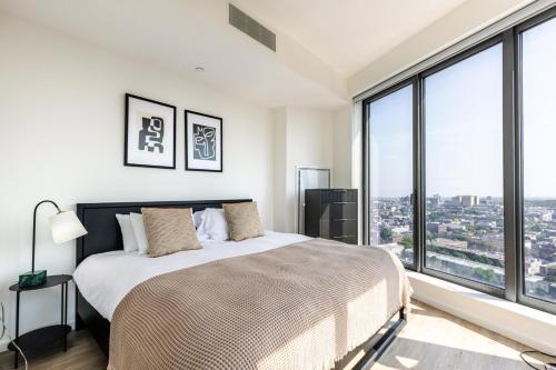 a bedroom with a large bed and large windows at Blueground Clinton Hill rooftop pool nr Prospect Park NYC-1961 in Brooklyn
