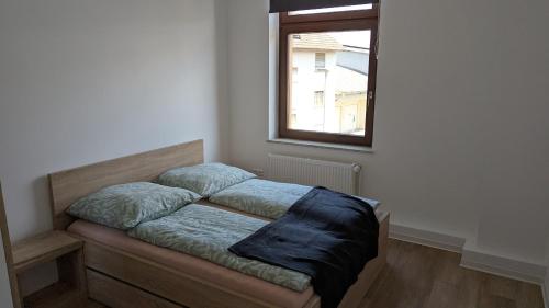 a bed sitting in a room with a window at Pension Sonne in Baden-Baden