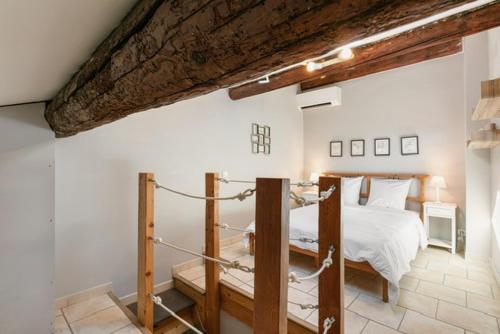 a bedroom with a white bed and a wooden ceiling at Duplex au cœur du vieil Antibes, Le Jamesy in Antibes