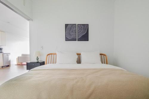 a bed in a white room with a picture on the wall at Blueground Downtown rooftop nr Marymoor Park SEA-890 in Redmond