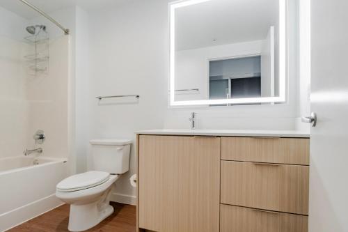 a white bathroom with a toilet and a sink at Blueground Downtown rooftop nr Marymoor Park SEA-890 in Redmond