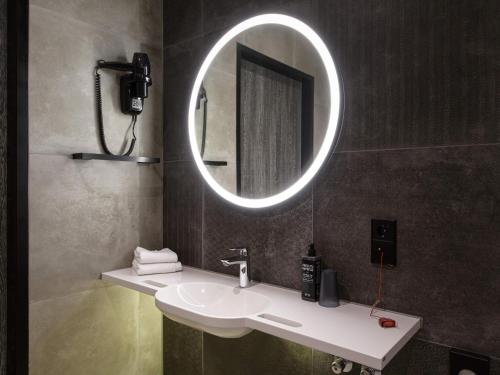 a bathroom with a sink and a mirror at ibis Styles Friedrichshafen in Friedrichshafen