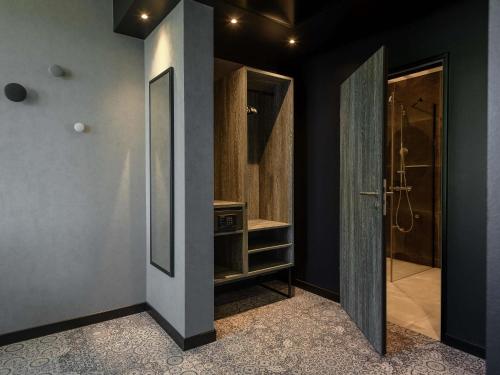 a bathroom with a walk in shower next to a door at ibis Styles Friedrichshafen in Friedrichshafen