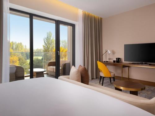 a hotel room with a bed and a large window at Swissôtel Wellness Resort Alatau Almaty in Almaty