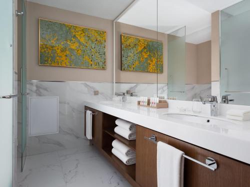 a bathroom with a sink and a shower and a mirror at Swissôtel Wellness Resort Alatau Almaty in Almaty