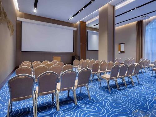 a conference room with a row of chairs and a screen at Swissôtel Wellness Resort Alatau Almaty in Almaty