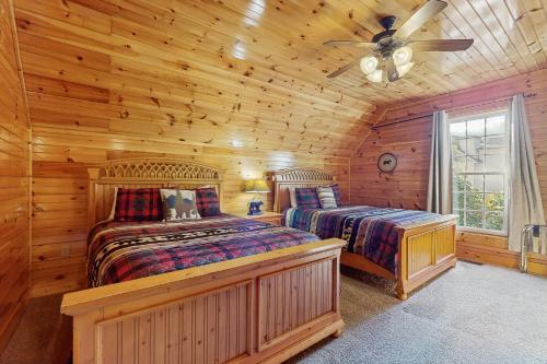 ein Schlafzimmer mit zwei Betten in einer Blockhütte in der Unterkunft Black Bear Hideaway Cabin in Gatlinburg