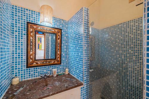 a blue tiled bathroom with a sink and a mirror at Dar Salah - Eddine Oasis Pool & SPA in Oulad Mazoug