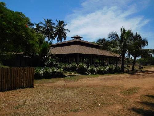 a building with palm trees in front of it at Ko-Sa Beach Resort Ltd in Ampeni