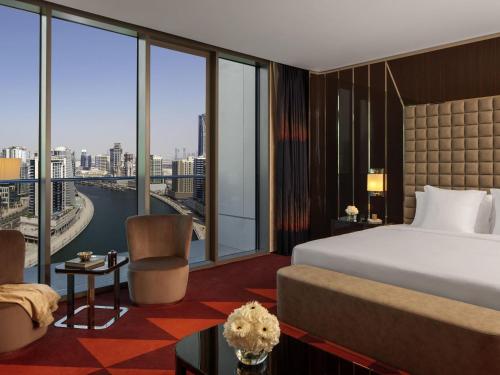 a hotel room with a bed and a large window at Hyde Hotel Dubai in Dubai