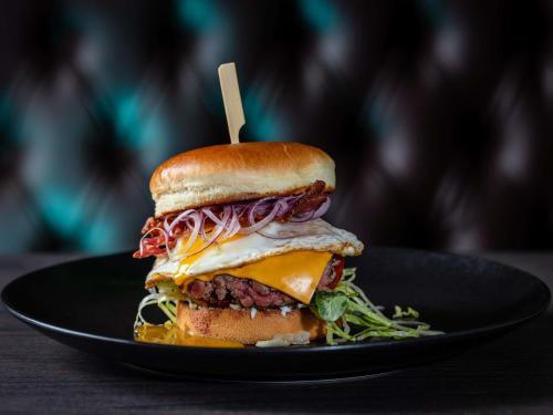 a sandwich on a plate with a wooden stick in it at ibis Styles Kiel City in Kiel