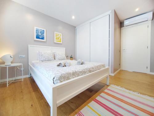a bedroom with a large white bed in a room at Bo&Co Apartments in Sitges