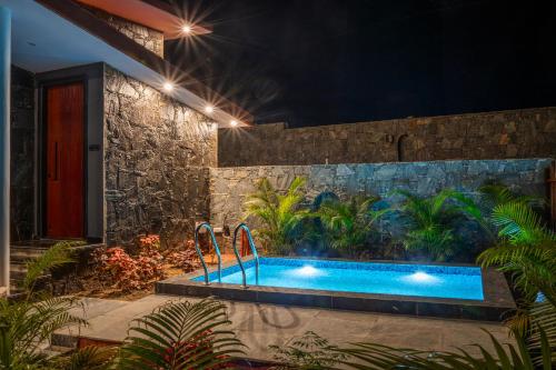 a swimming pool in a garden at night at Avanta by Aaryam, Kumbhalgarh in Kumbhalgarh