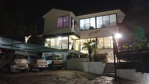 a house with cars parked in front of it at night at Hotel inti huasi in Villa Carlos Paz