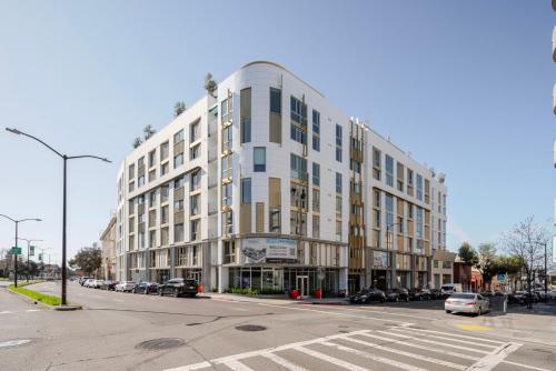 un gran edificio blanco en una calle de la ciudad con coches aparcados en Blueground Downtown Berkeley rooftop nr UC Berkeley SFO-1955, en Berkeley