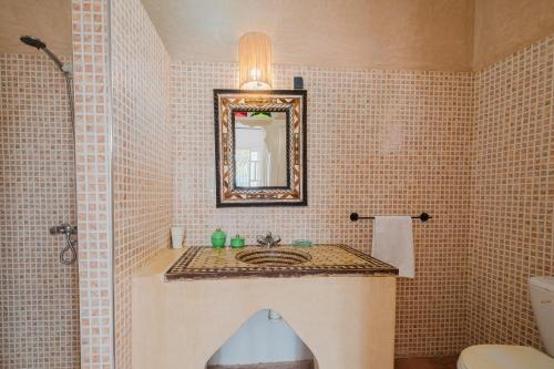 a bathroom with a sink and a mirror at Dar Salah - Eddine Oasis Pool & SPA in Oulad Mazoug