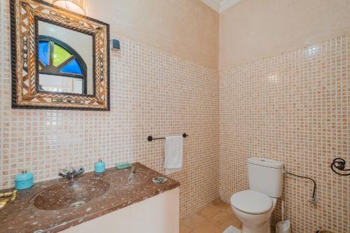 a bathroom with a sink and a toilet and a mirror at Dar Salah - Eddine Oasis Pool & SPA in Oulad Mazoug