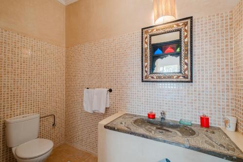 a bathroom with a sink and a toilet and a mirror at Dar Salah - Eddine Oasis Pool & SPA in Oulad Mazoug