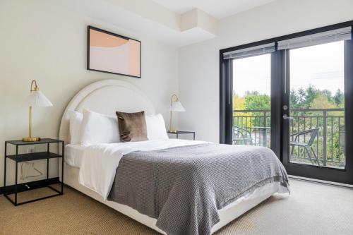 ein weißes Schlafzimmer mit Bett und Balkon in der Unterkunft Blueground Northeast Bellevue rooftop nr Lake SEA-909 in Highlands