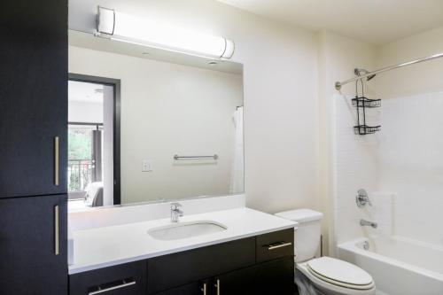 ein Badezimmer mit Waschbecken, Toilette und Spiegel in der Unterkunft Blueground Northeast Bellevue rooftop nr Lake SEA-909 in Highlands