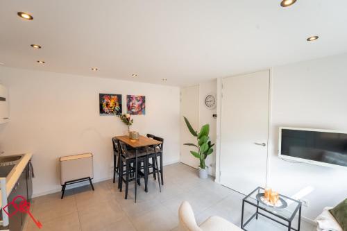 a living room with a kitchen and a table at In the heart of Tilburg in Tilburg