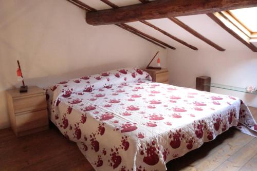 a bedroom with a bed with a red and white blanket at Biker house in Ronciglione