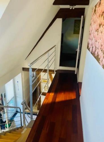 a staircase in a house with wooden floors and a stair case at Chez Litchee in Vendenheim