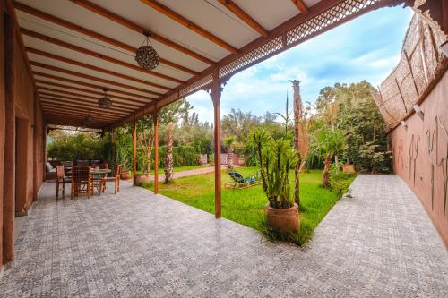 an outdoor patio with a table and chairs at Dar Salah - Eddine Oasis Pool & SPA in Oulad Mazoug