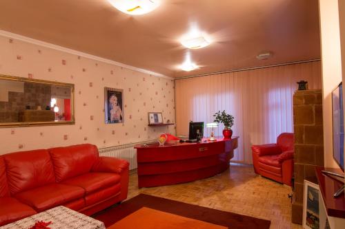 sala de estar con muebles de cuero rojo y escritorio en Accommodation Zara, en Vukovar