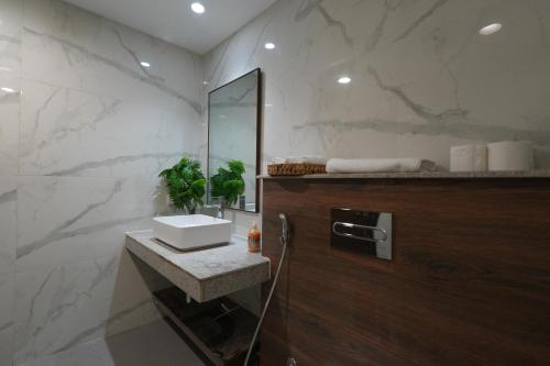 a bathroom with a sink and a mirror at Penta Square Executive Hotel Apartments City View DHA Lahore in Lahore