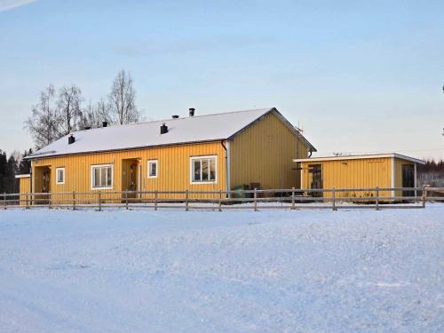 a yellow building with a fence in the snow at Annexet 1 & 2 in Fränsta