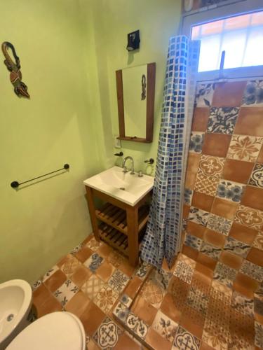 a bathroom with a sink and a toilet and a mirror at La Herminda Casas de Campo in Nono
