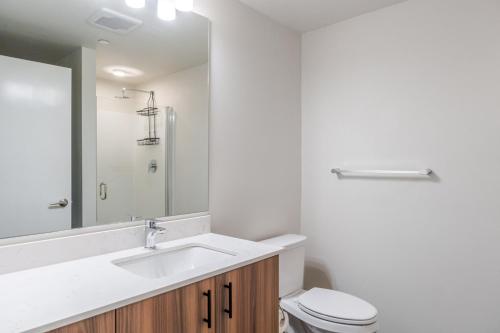 a bathroom with a sink and a toilet and a mirror at Blueground Meridian Park rooftop BBQ nr Park SEA-933 in Shoreline