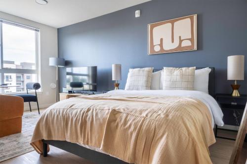 a bedroom with a large bed with a blue wall at Blueground Meridian Park view nr Shoreline Park SEA-932 in Shoreline