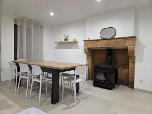ein Esszimmer mit Tisch und Kamin in der Unterkunft Charmante maison de pierre rénovée a 5min de Charleville-Mézières in Saint-Marceau