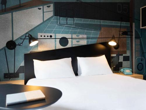 a bedroom with a bed and a kitchen at ibis Styles Dreux Centre Gare in Dreux