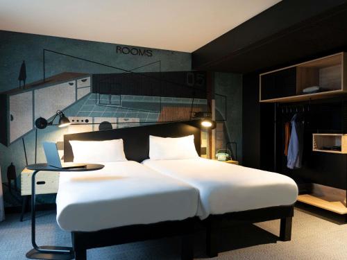 a bedroom with a bed and a laptop on a table at ibis Styles Dreux Centre Gare in Dreux